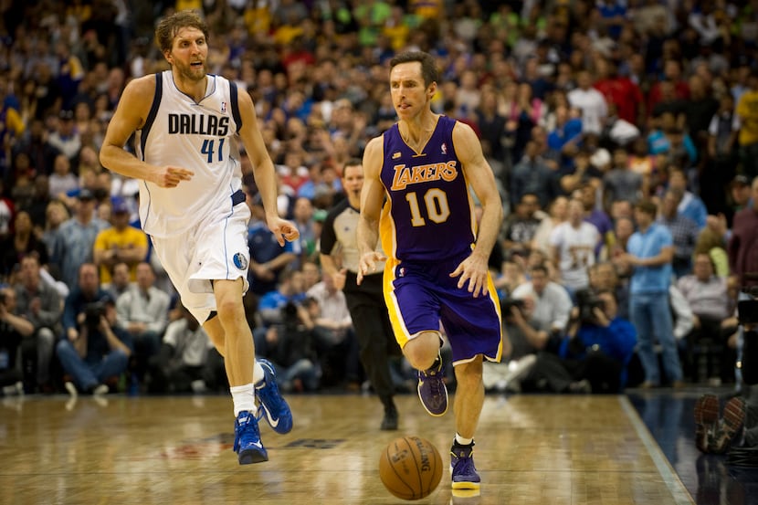 Steve Nash (10) of the Los Angeles Lakers brings the ball up the court past Dirk Nowitzki...