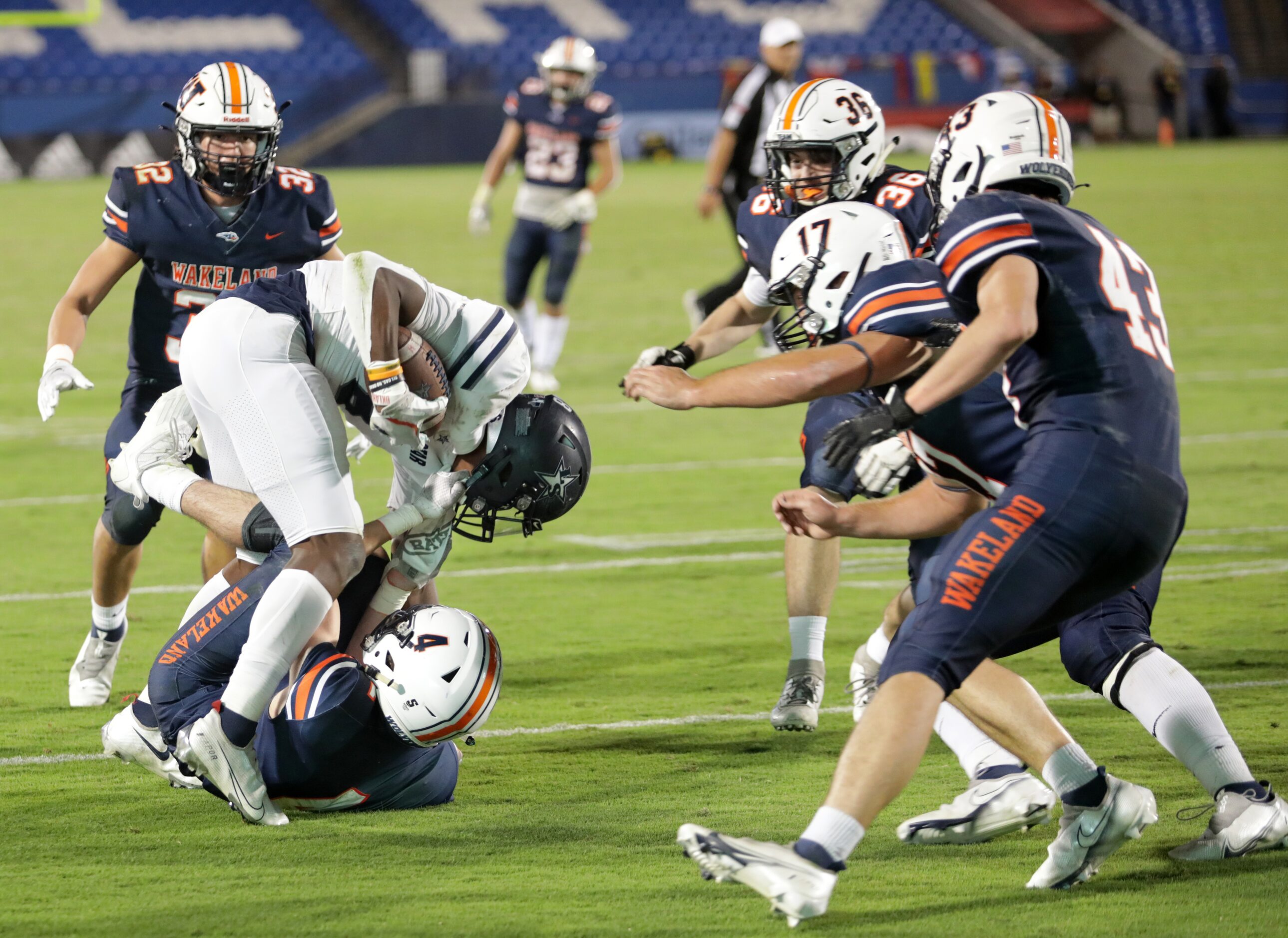 Lone Star player #8, Devin Turner, is tackled by Wakeland player #4, Gus England, during a...