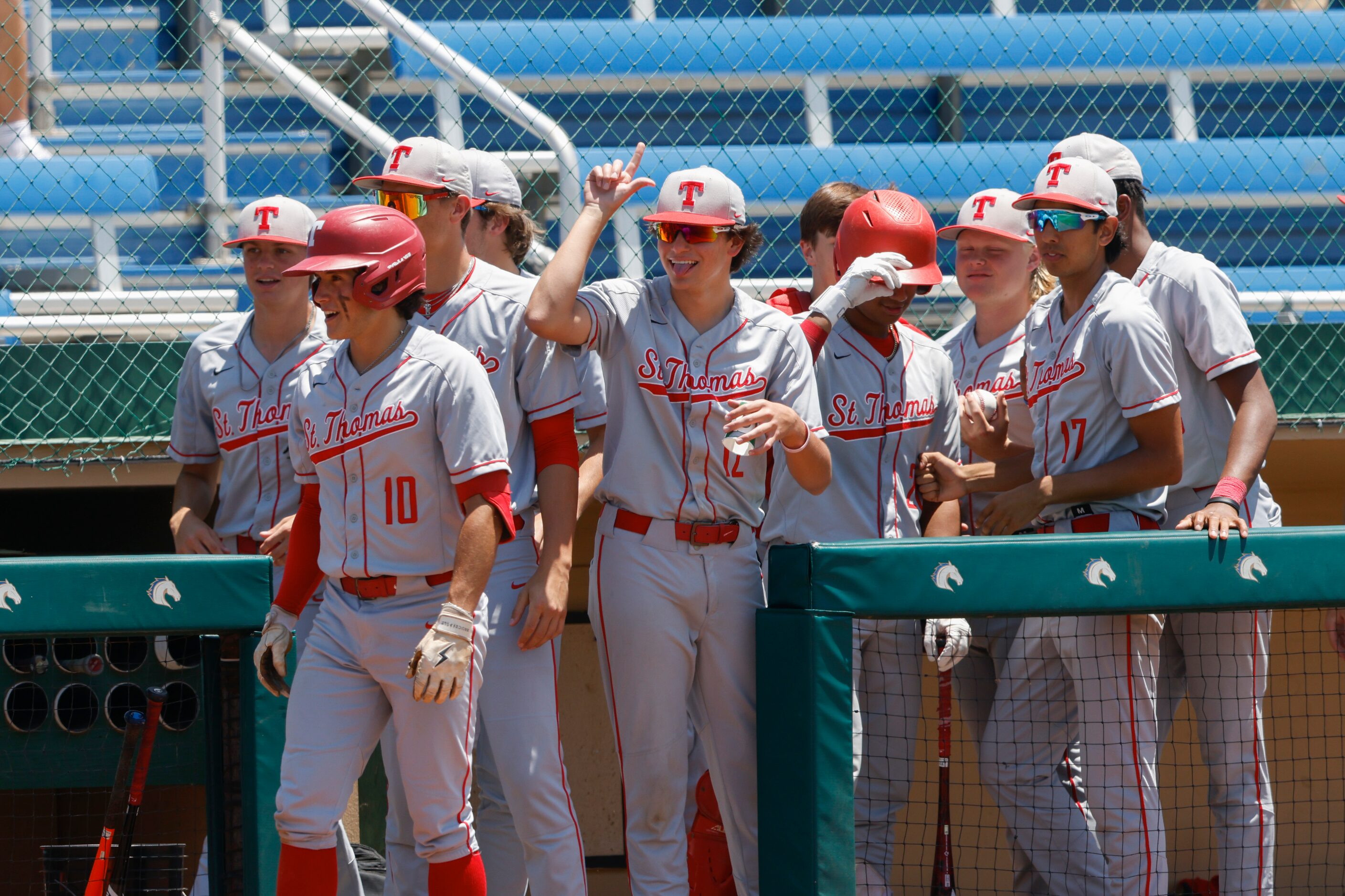 Houston St. Thomas players celebrate after scoring three runs in against Trinity Christian...