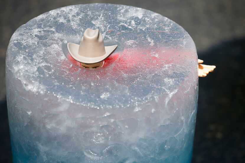 Ice melts around a 13-inch tall plastic Big Tex toy on the rooftop of The Dallas Morning...