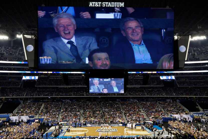 Former presidents Bill Clinton, left, and George W. Bush watch action between Connecticut...