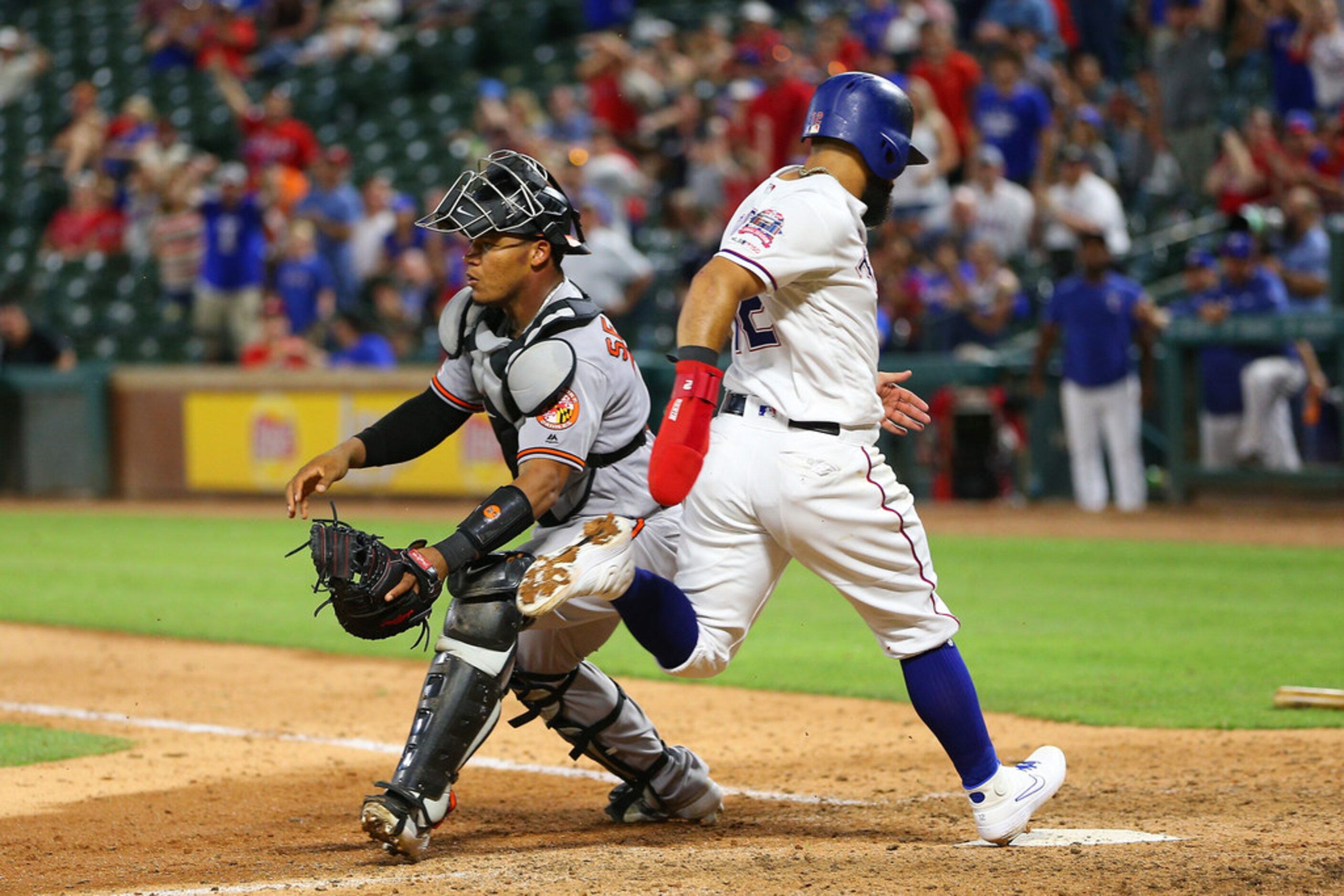 ARLINGTON, TX - JUNE 04: Rougned Odor #12 of the Texas Rangers scores against Pedro Severino...