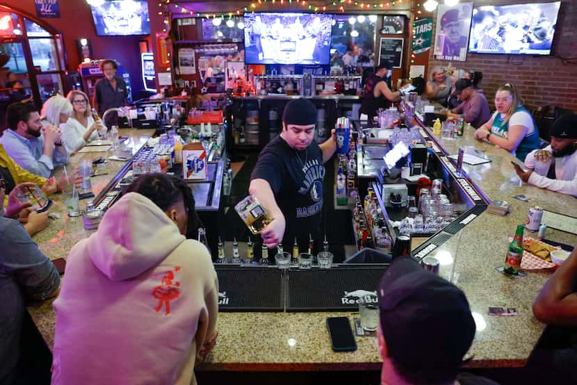 Bartender Nathan Bahrami (center) serves drinks to customers on Thursday, May 30, 2024, at...