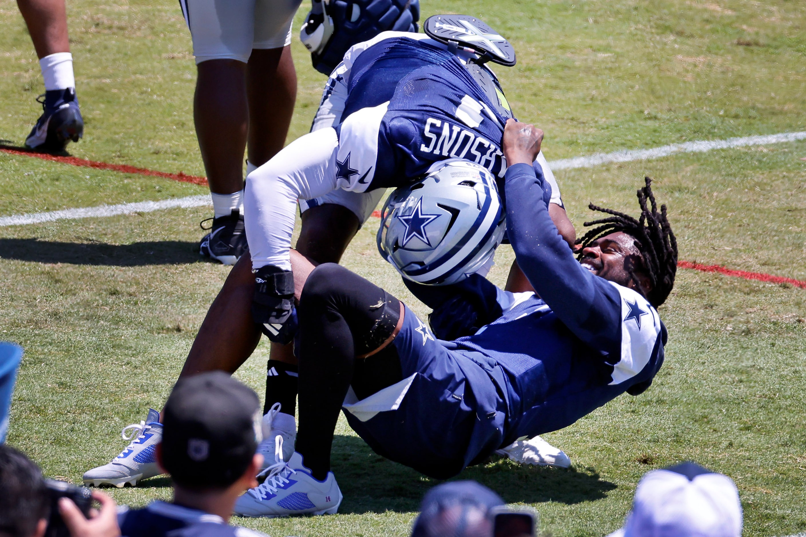 Dallas Cowboys linebacker Micah Parsons (11) drops cornerback Trevon Diggs (7) as the two...