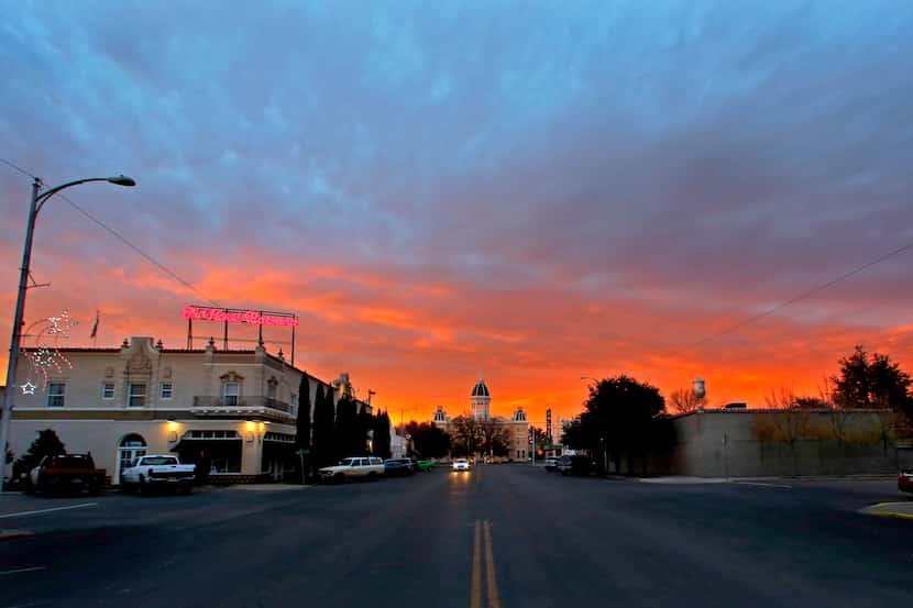 The sun sets over Hotel Paisano and the Presidio County Courthouse in Marfa, Texas. (Guy...
