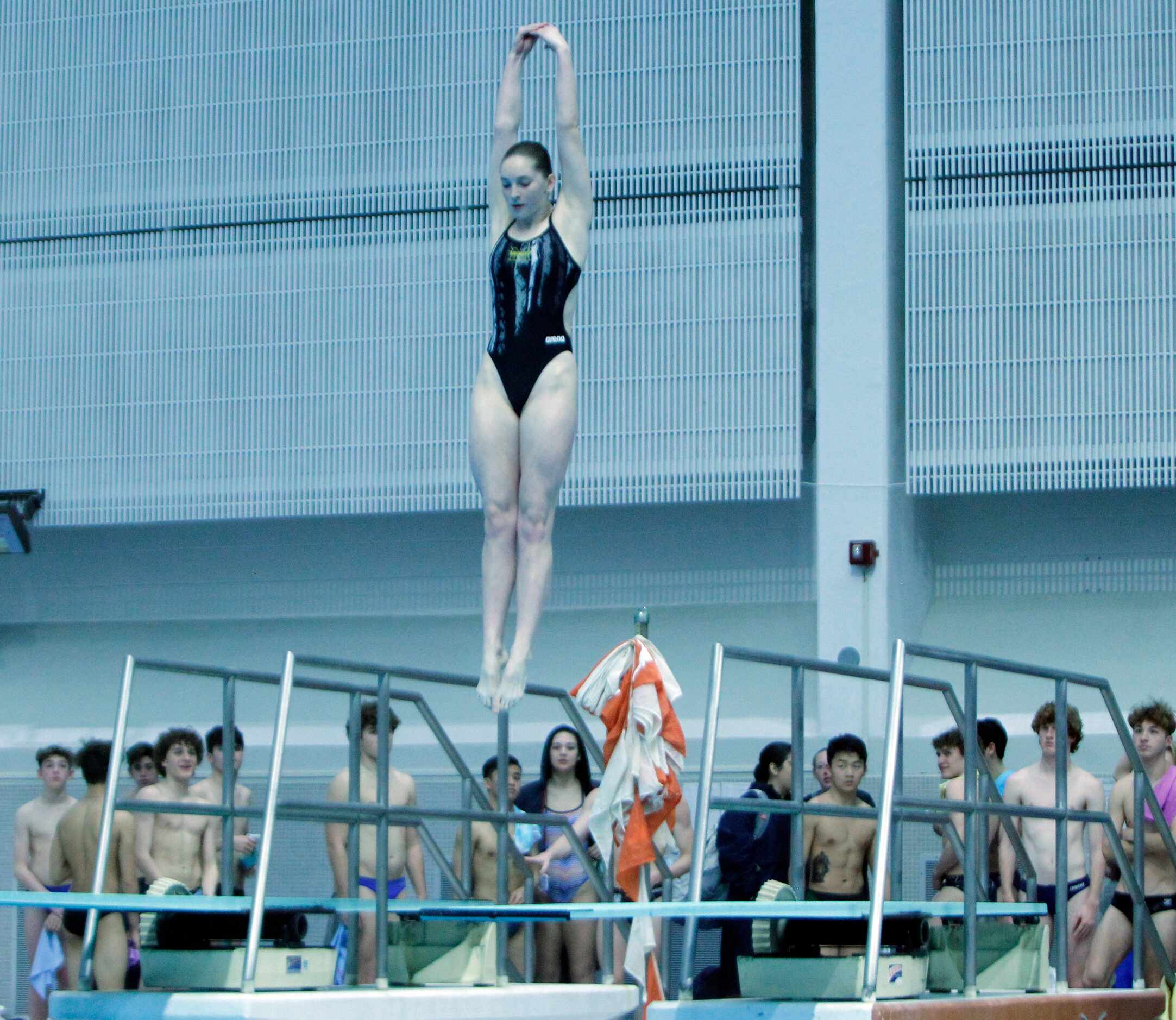 Frisco Memorial diver Peyton Guziec elevates in her dive as fellow competitors look on...