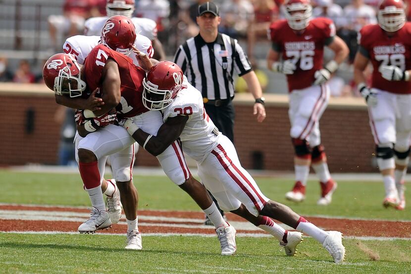 Oklahoma wide receiver Jordan Smallwood (17) is tackled by Sooners linebacker Aaron Franklin...