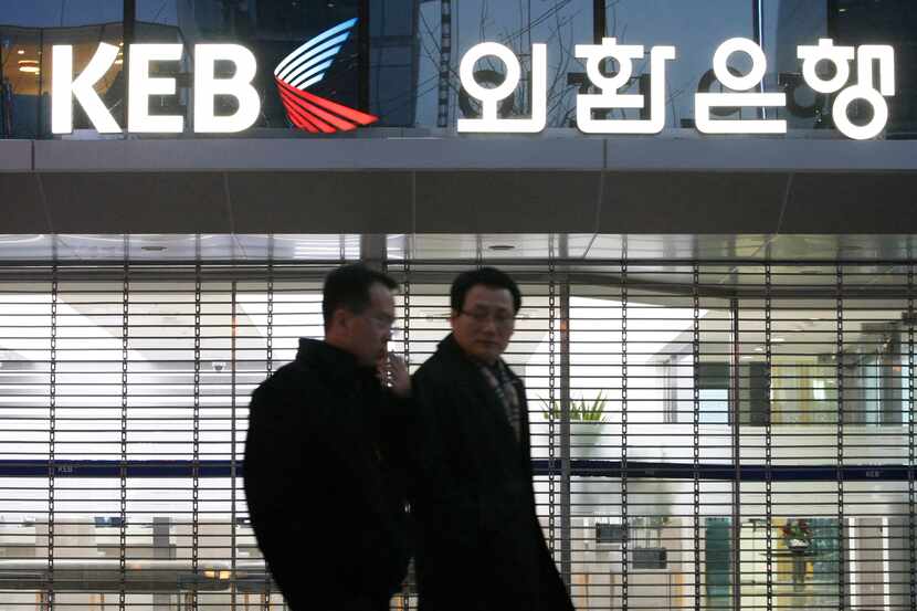 Customers walk by Korea Exchange Bank headquarters in Seoul, South Korea. The government...