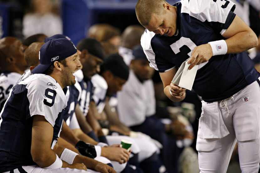 Dallas Cowboys quarterback Tony Romo (9) and quarterback Jon Kitna joke on the bench during...