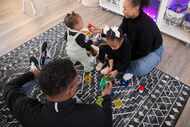 Kenneth, left, and Daizha Rioland play with their daughters, 9-month-old Izabella and Alani,...