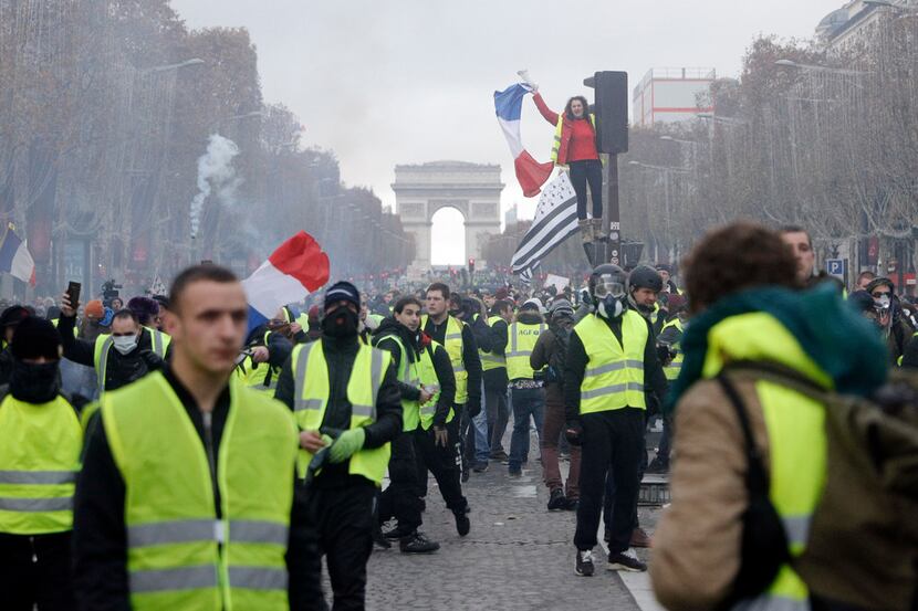 Demonstrators march on the famed Champs-Elysees avenue in Paris, France, as they protest...