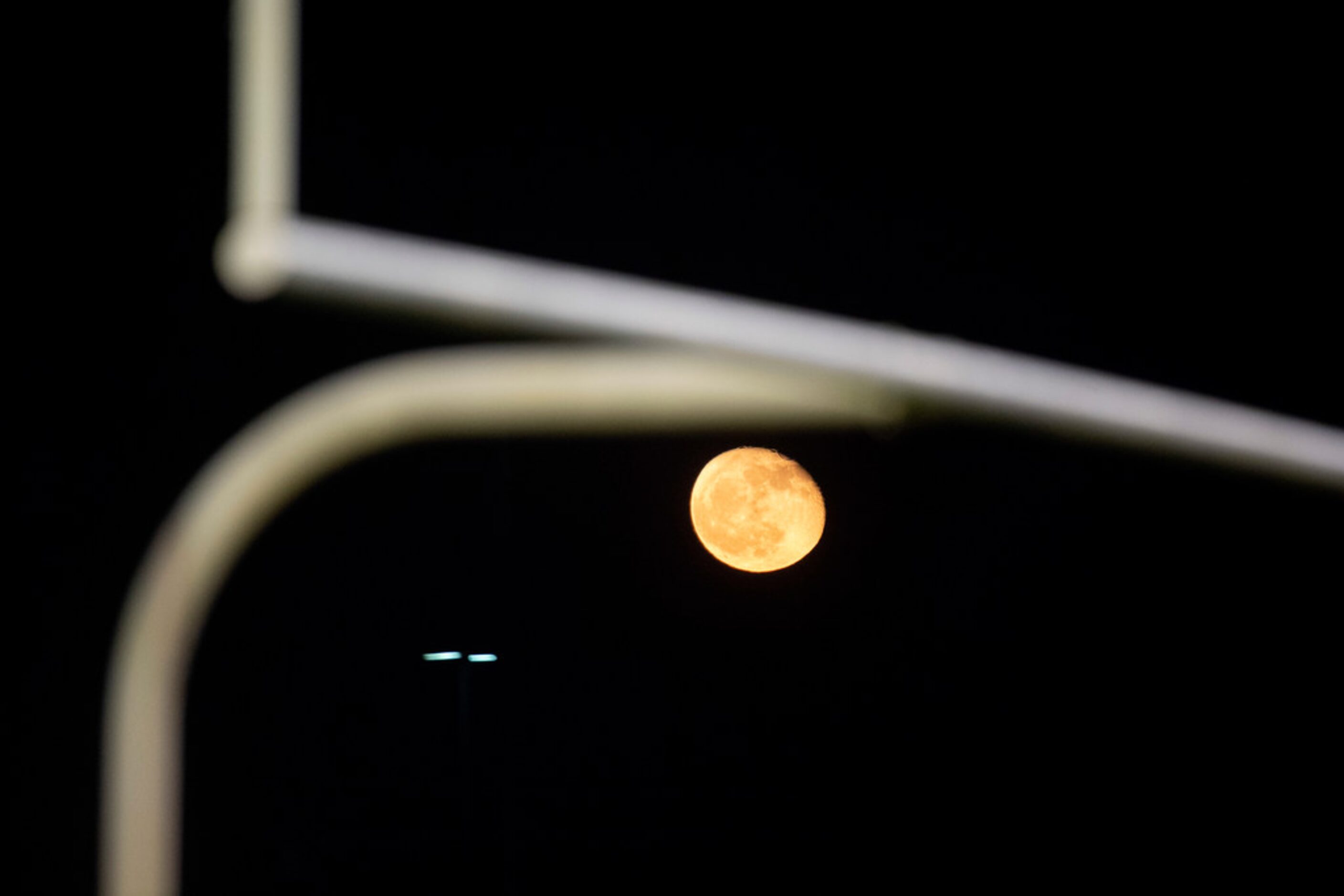 The moon rises behind the goalposts during the second half of a high school football game...