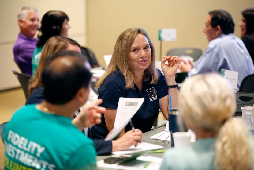 Keller personal finance teacher Megan Schank (center) works with her group on a financial...