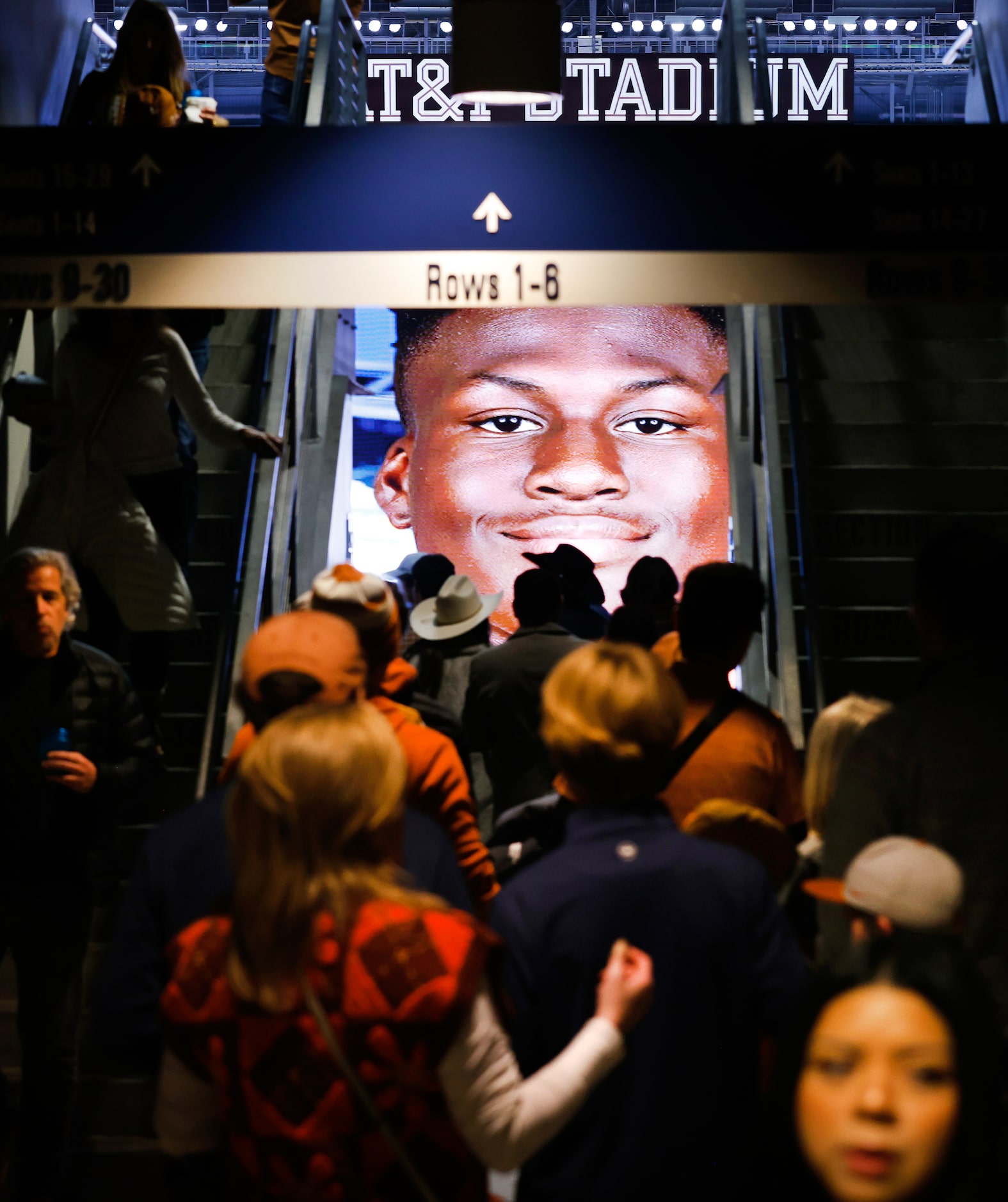 Texas Longhorns fans make their way to their upper concourse seats as players were shown on...