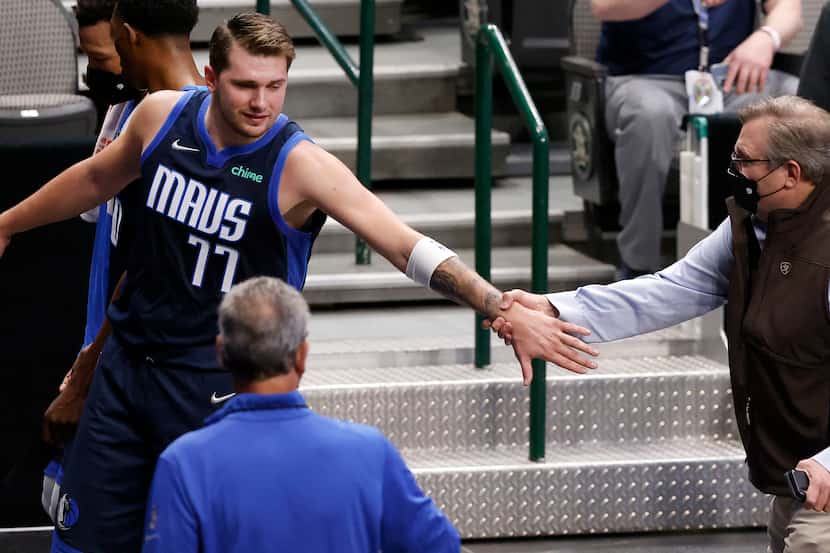 Dallas Mavericks guard Luka Doncic (77) reaches back for General Manager Donnie Nelson as...