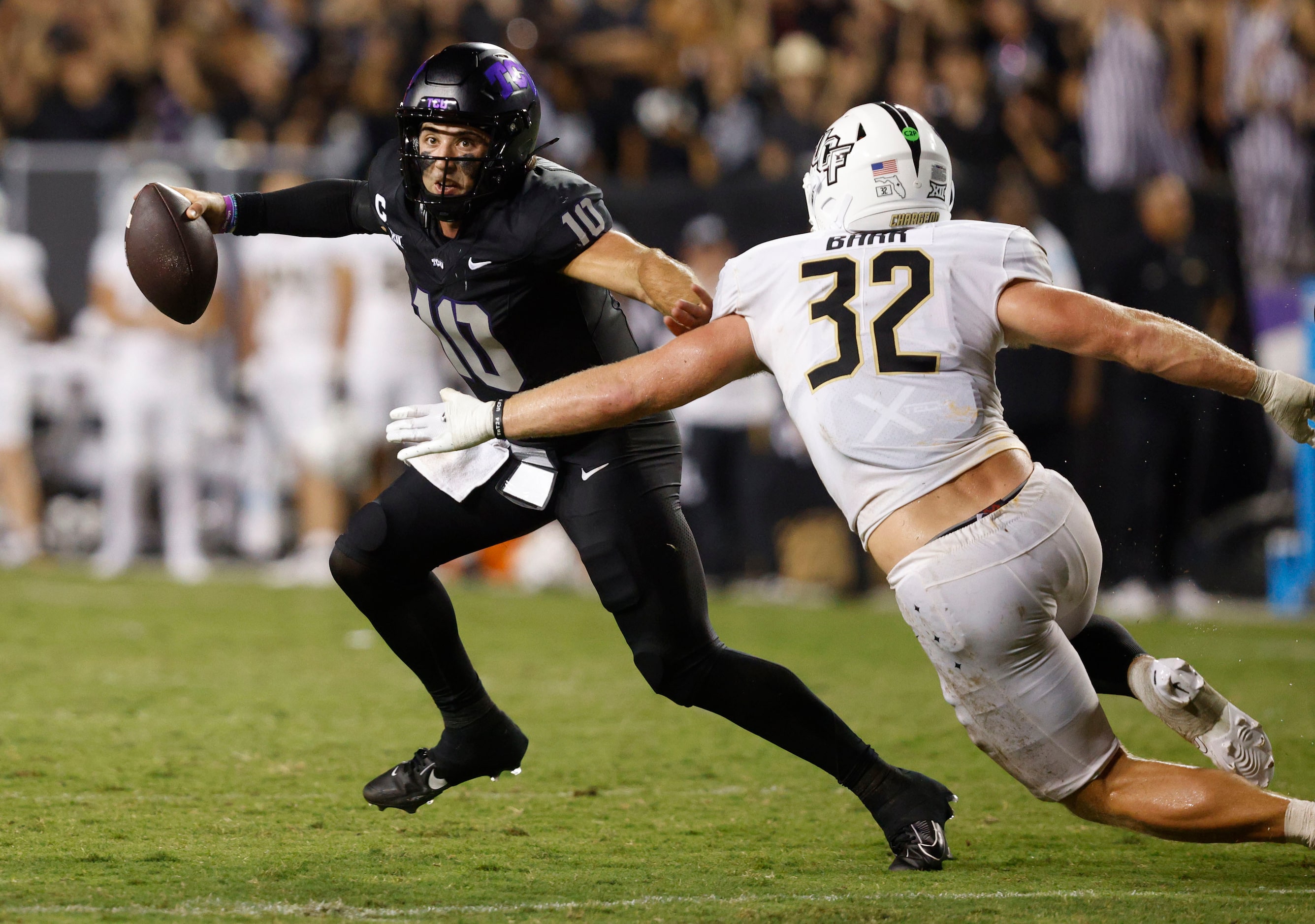 TCU quarterback Josh Hoover (10) looks to throw the ball Under pressure from UCF linebacker...