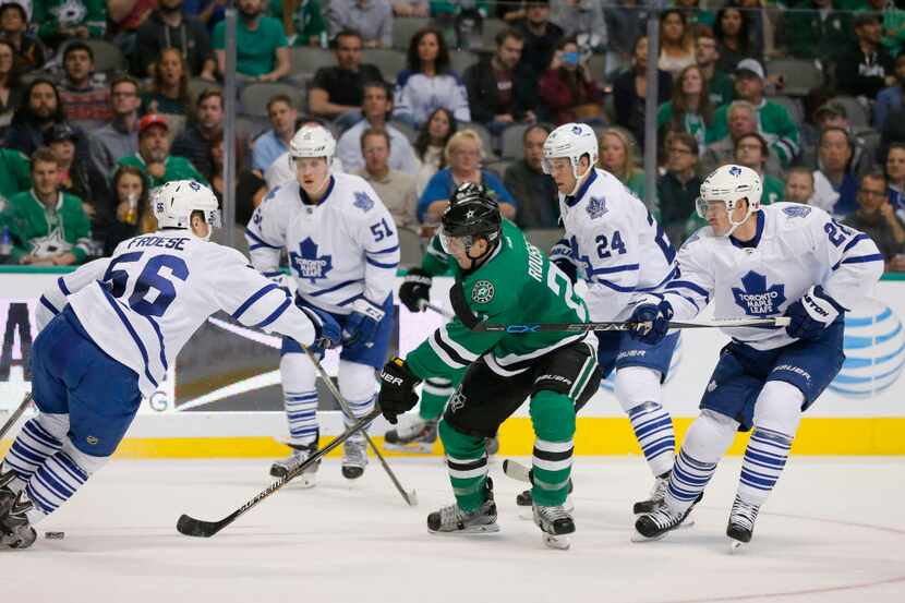 Dallas Stars' Antoine Roussel (21) of France unsuccessfully attempts to gain control of a...