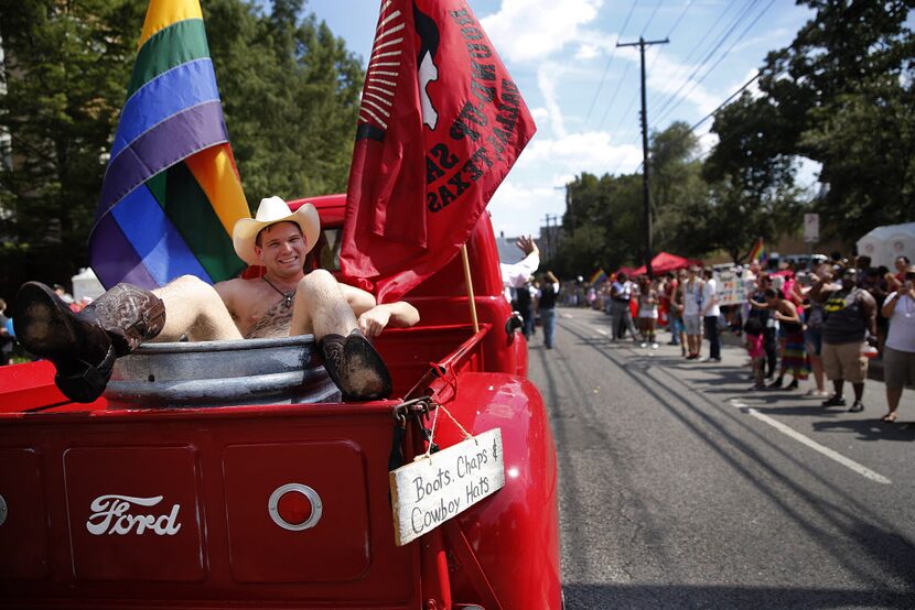 A 'naked' cowboy rides in the back of an old Ford pickup sponsored by the Round-Up Saloon...