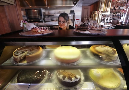 Desirae Kay arranges the cake display at Cafe Intermezzo in Plano.