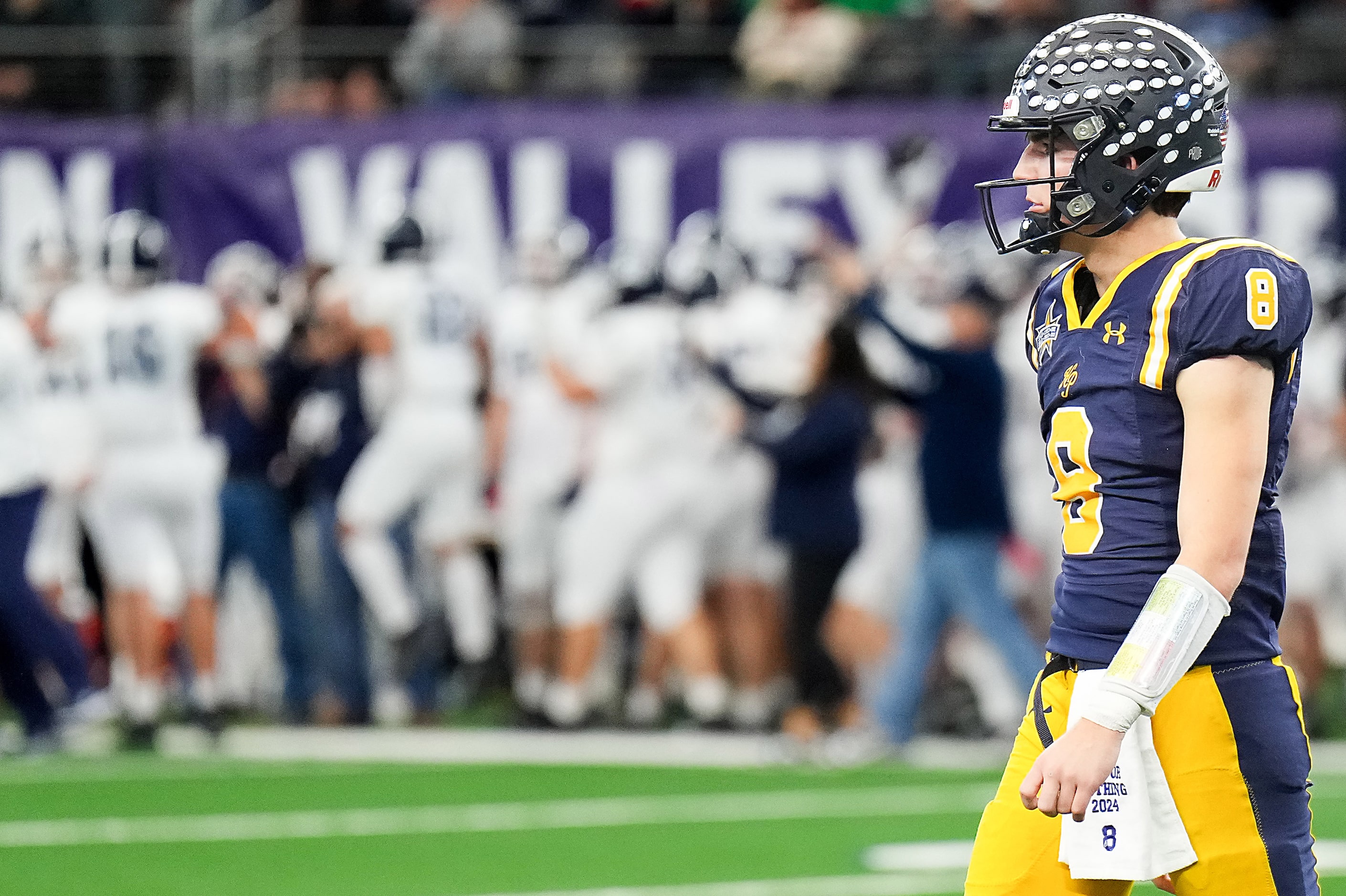 Highland Park quarterback Buck Randall walks to the bench as Smithson Valley players...