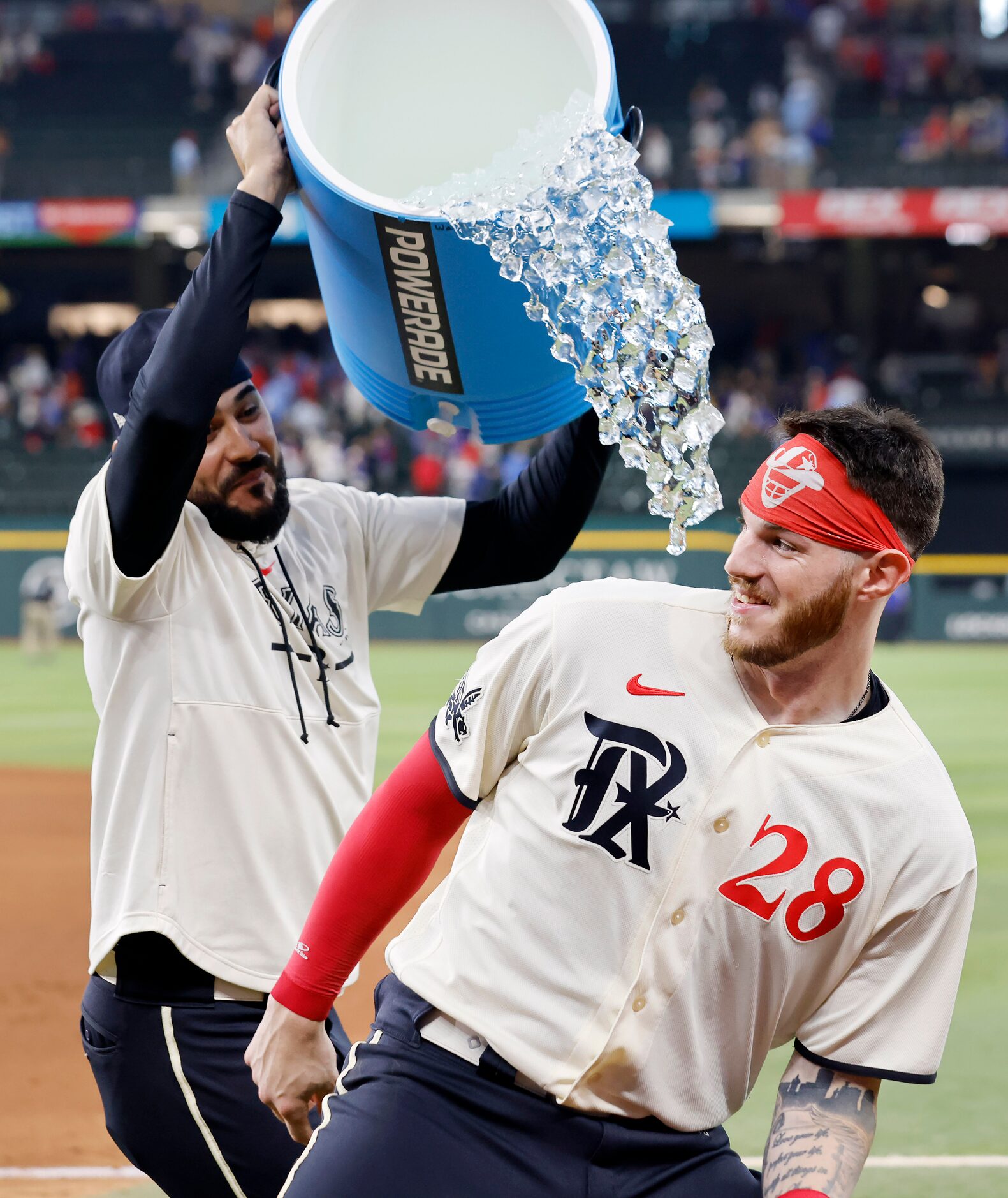 Texas Rangers catcher Jonah Heim (28) avoids the initial ice water dump from starting...