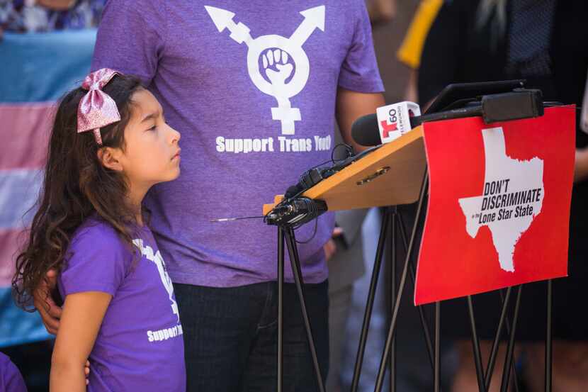Libby Gonzales, 7, who is transgender, stands with her father, Frank Gonzales, as he speaks...