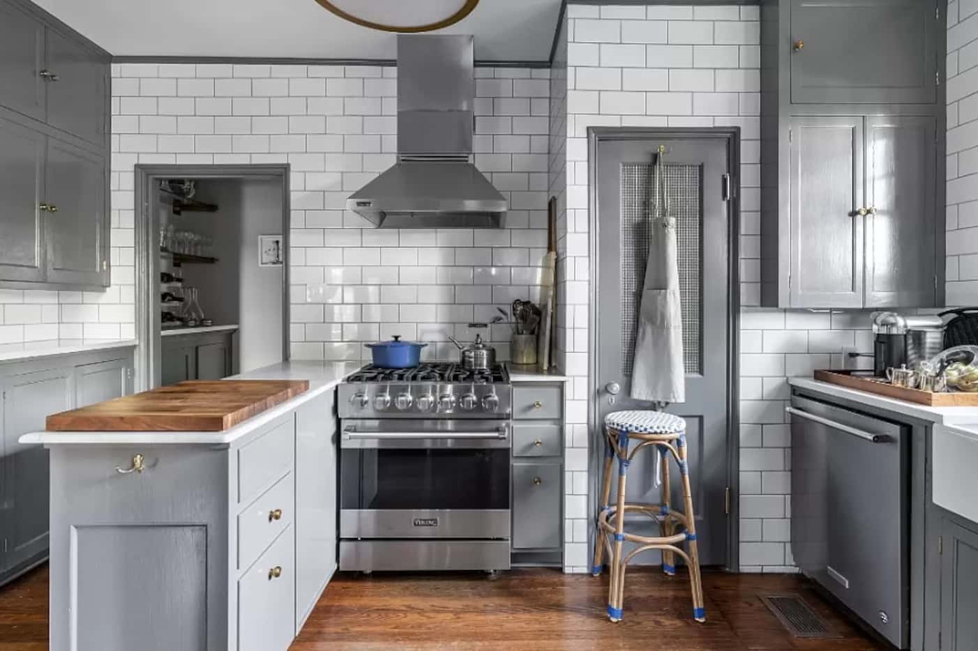 Kitchen with white subway tile, gray cabinetry and stainless appliances