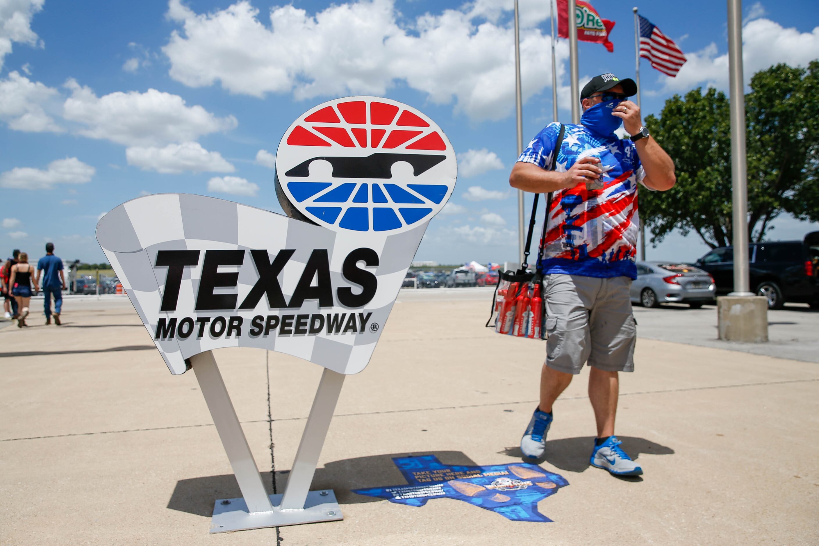 A fan adjusts his face mask before entering Texas Motor Speedway for the NASCAR Cup Series...
