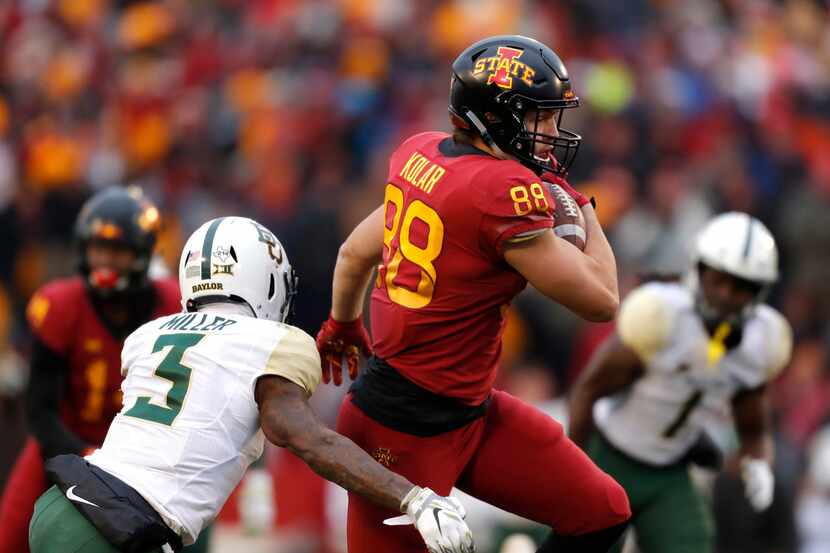 Iowa State tight end Charlie Kolar, right, tries to elude a tackle by Baylor safety Chris...