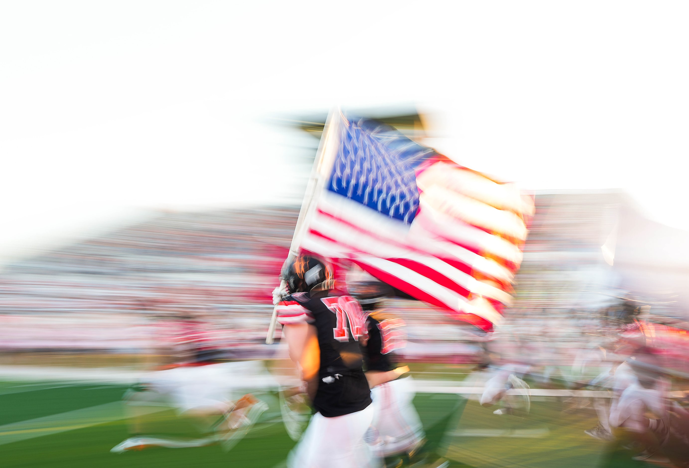 Rockwall offensive lineman Cooper Sanborn (70) carries the American flag as his team takes...