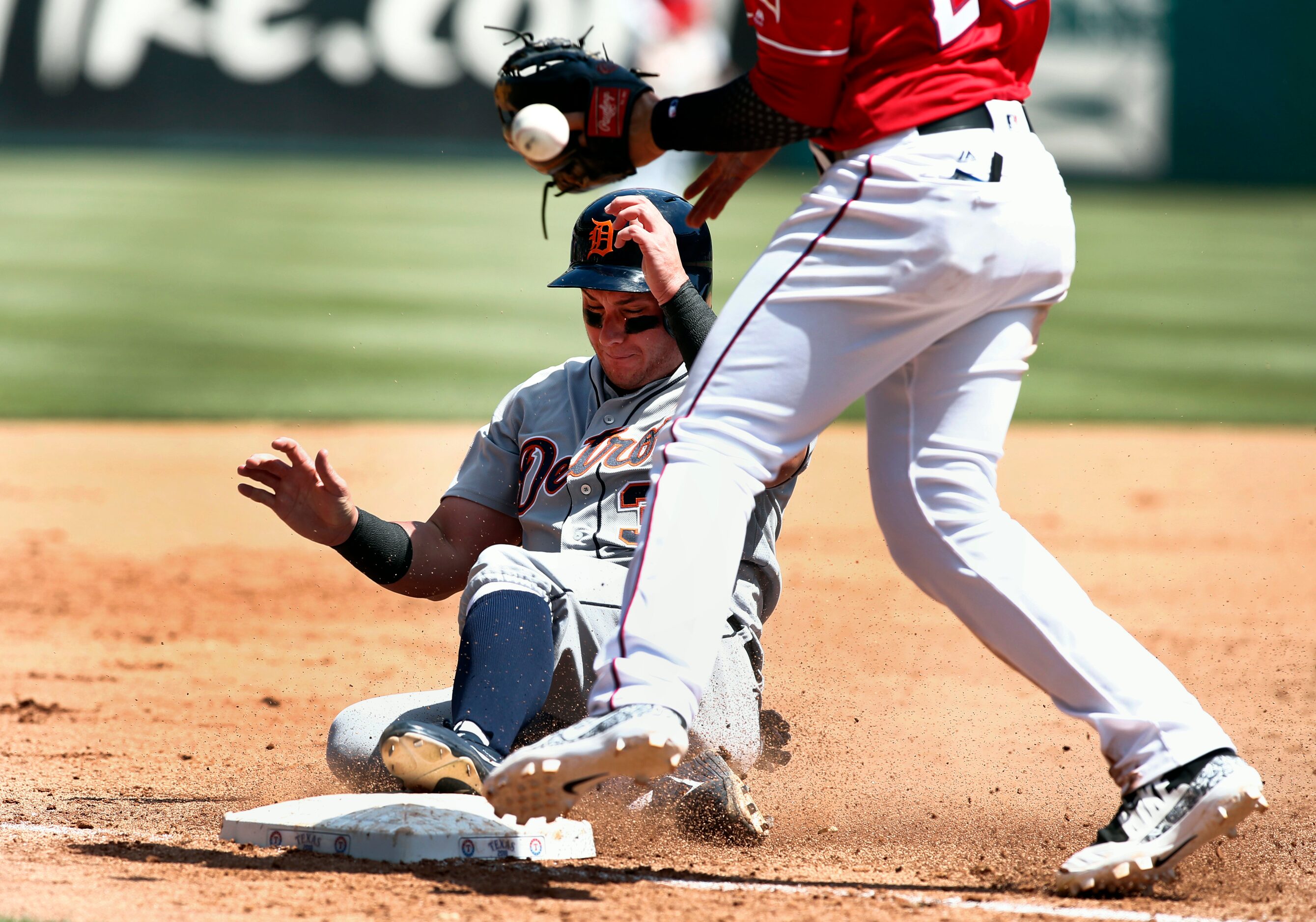 Detroit Tigers' James McCann (34) slides safely into third base as Texas Rangers third...