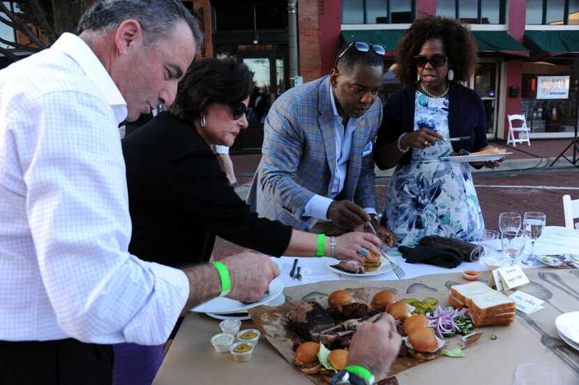 Plano Mayor Harry LaRosiliere and wife Tracy select food for their plates at Night Out on...