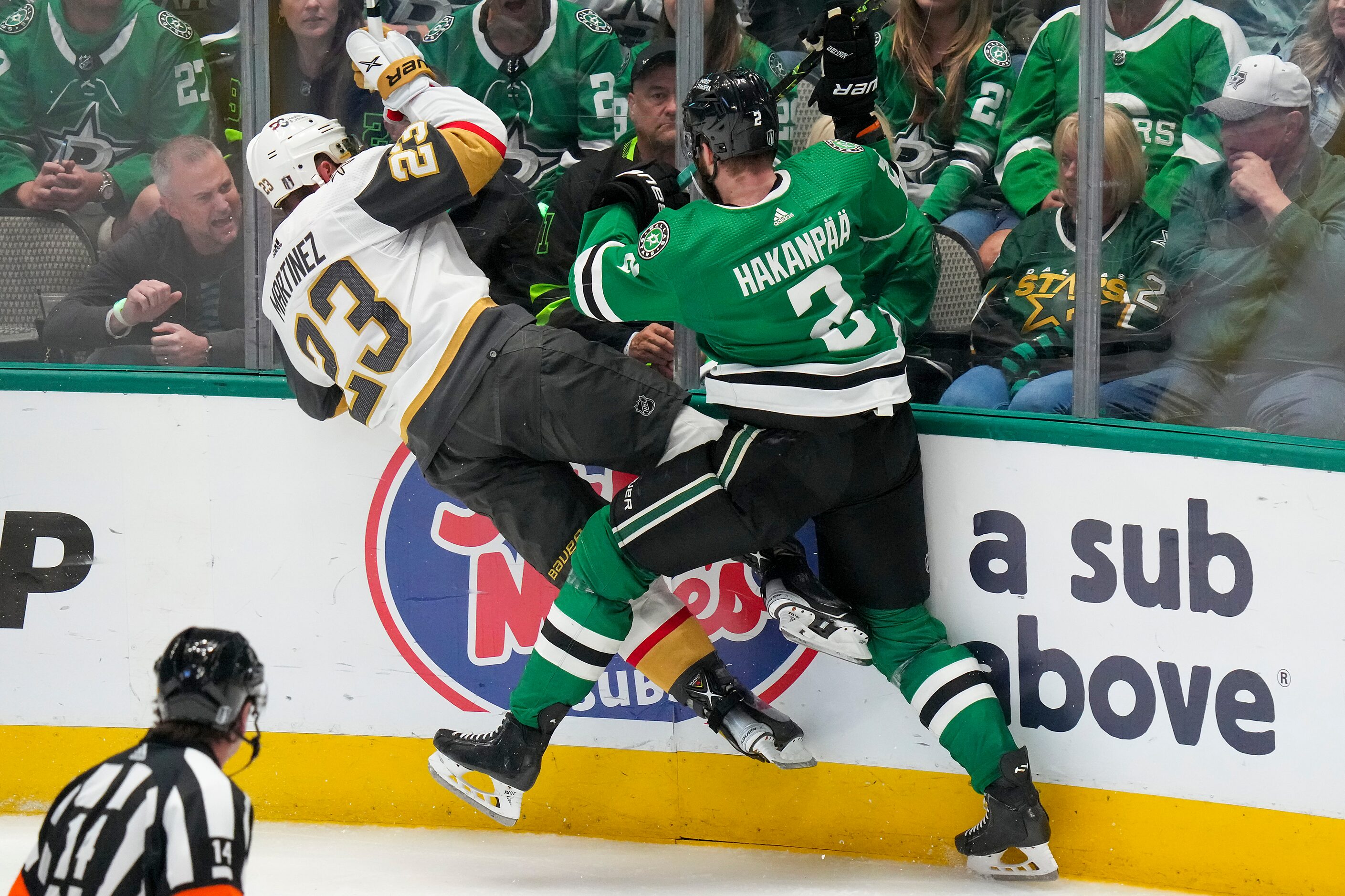 Vegas Golden Knights defenseman Alec Martinez (23) is checked by Dallas Stars defenseman...