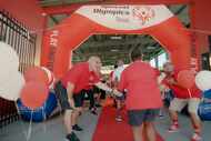 Atheletes in red T-shirts run down a red carpet slapping hands of Coca-Cola Southwest...