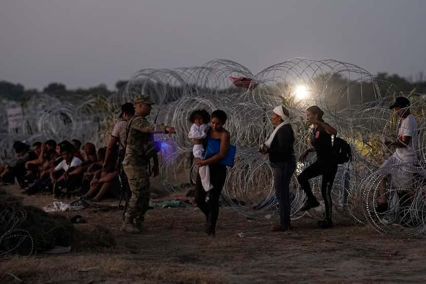 FILE - Migrants who crossed the Rio Grande and entered the U.S. from Mexico are lined up for...