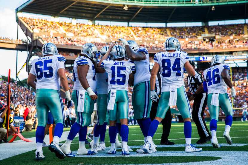Dallas Cowboys celebrate with wide receiver Devin Smith (15) after he scored a touchdown...
