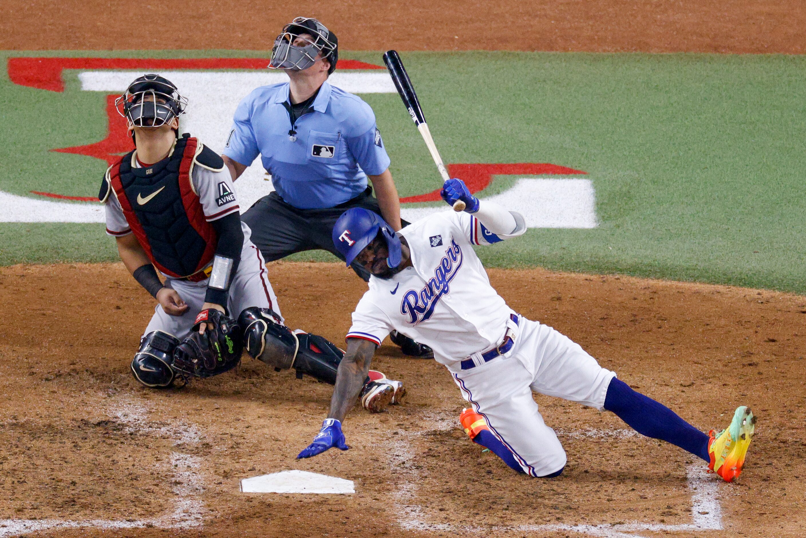 Texas Rangers right fielder Adolis Garcia (53) slips after fouling off a pitch during the...