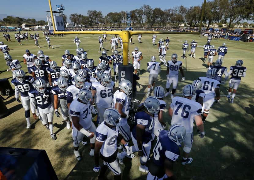 Dallas Cowboys players circle the goal post as is routine at the beginning of afternoon...