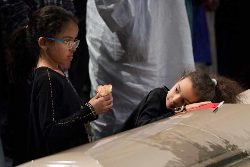 Two young girls reflect next to a casket of one of the six victims of the Quebec City mosque...