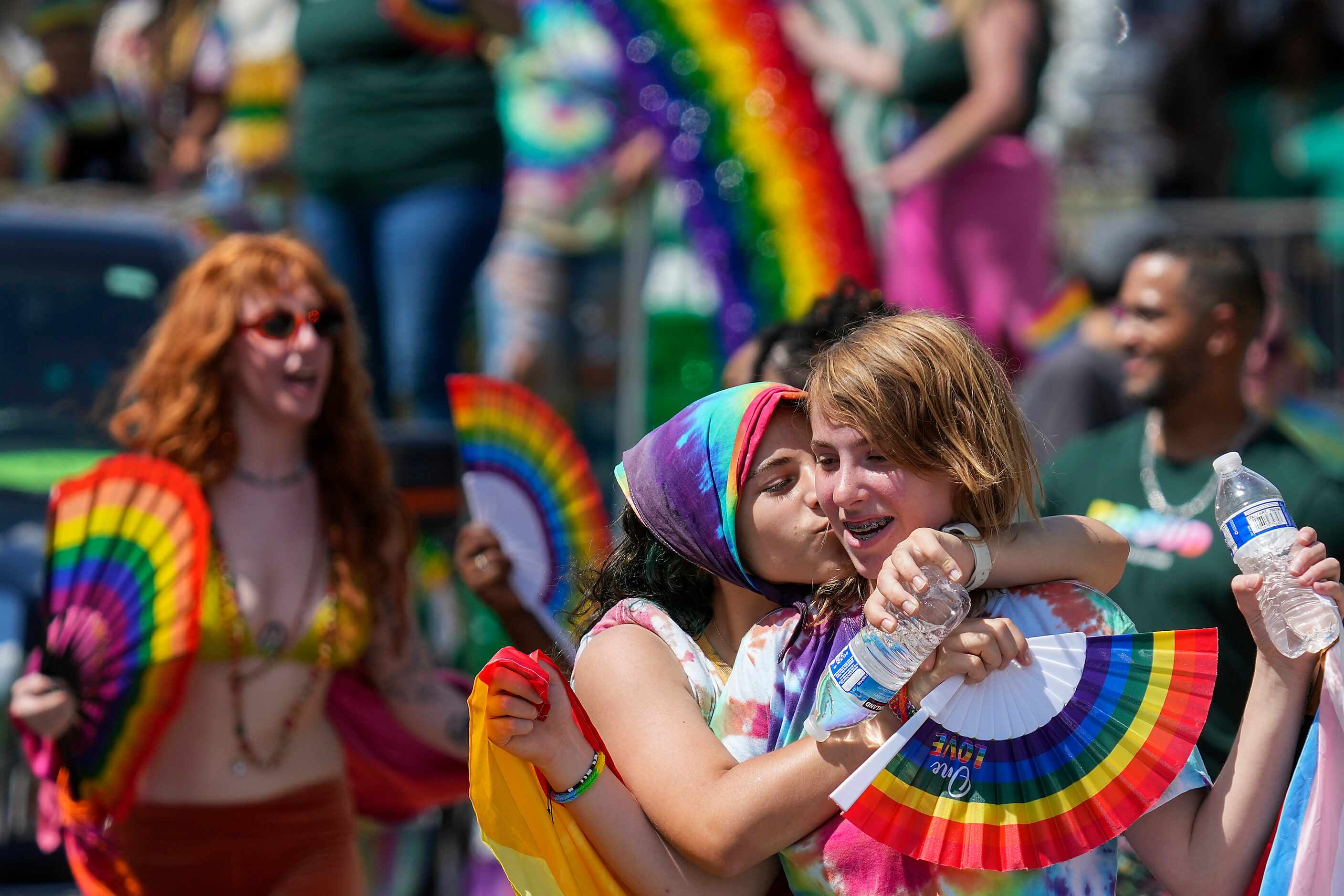 Kailey Bickham gets a kiss from Mira Jabba
as they march through Fair Park during the annual...