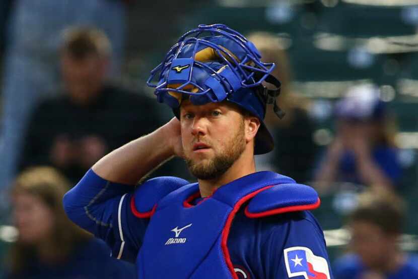 Texas Rangers catcher Bryan Holaday gets ready to catch against the Cleveland Indians in...