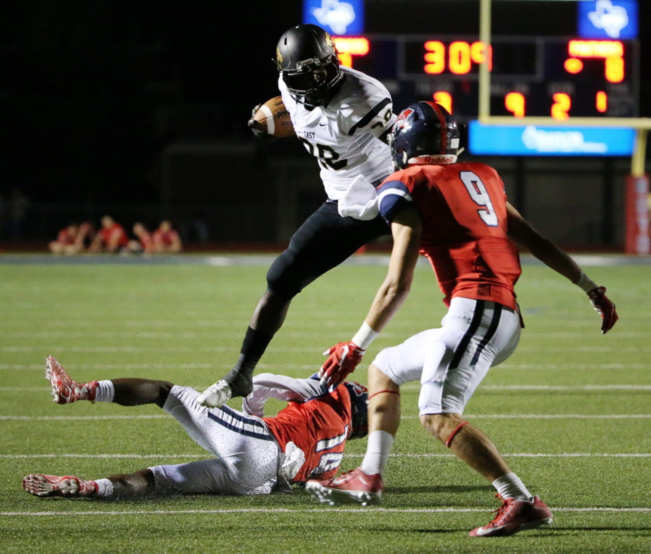 Plano East running back Desmond Bowden (28) leaps over McKinney Boyd defensive back Armani...