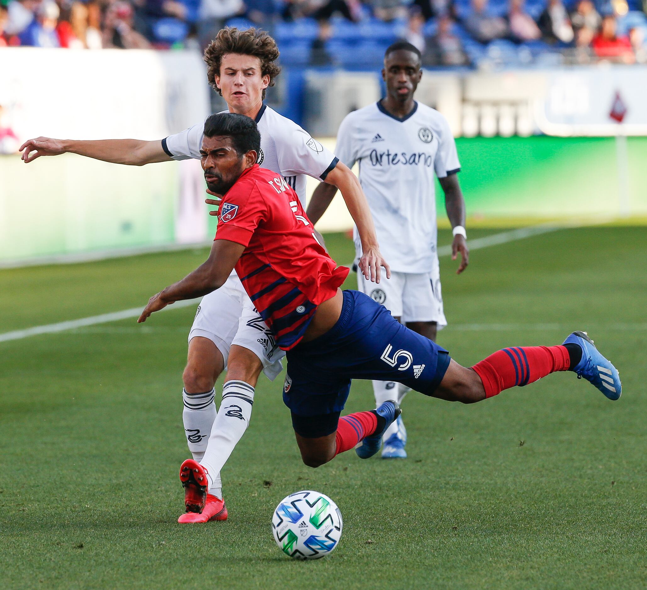 FC Dallas midfielder Thiago Santos (5) is upended while battling with Philadelphia Union...