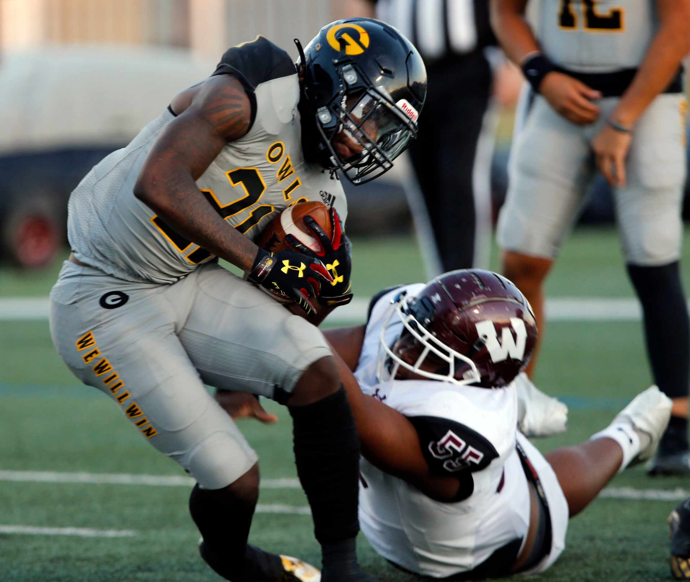 Garland RB Jayshon Powers (21) works to hang on, as Wylie defender Cam Draper (55) tries to...