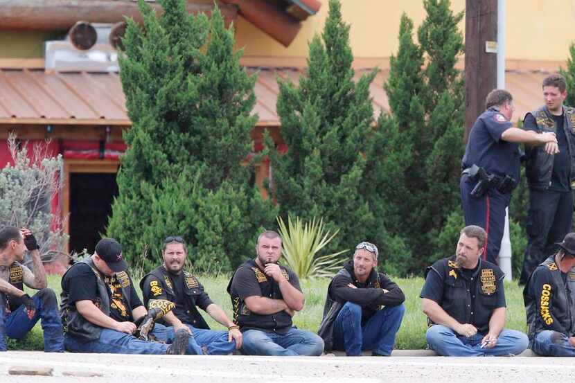 
Bikers waited in a line Sunday as law enforcement officers removed the suspects’ boots and...