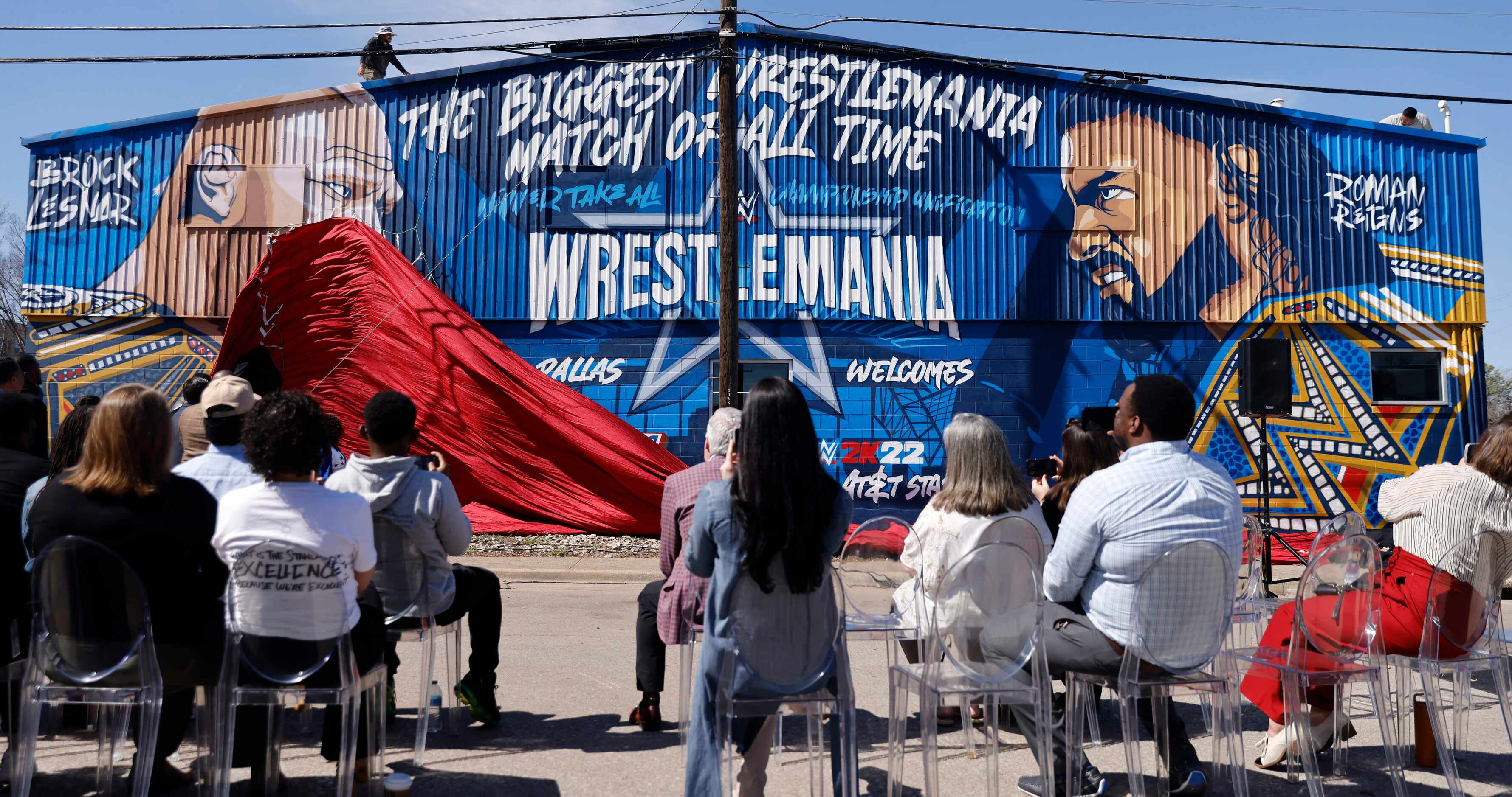 Crews drop the curtain on a WrestleMania mural in West Dallas, March 3, 2022. Superstar Drew...