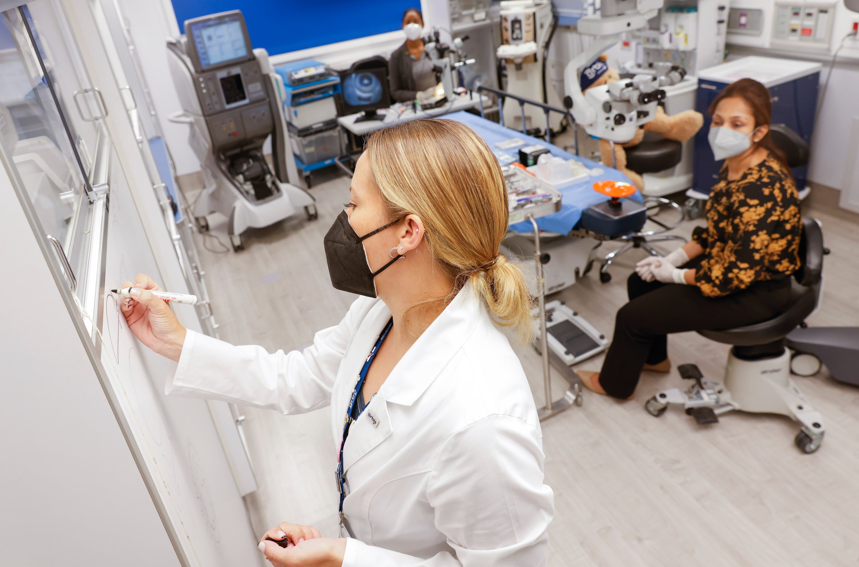 Orbis Flying Eye Hospital instructor Dr. Maria Montero, front, instructs resident Ciara...