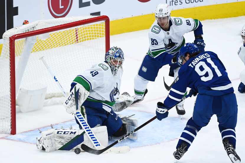 Vancouver Canucks goaltender Braden Holtby (49) stops Toronto Maple Leafs centre John...