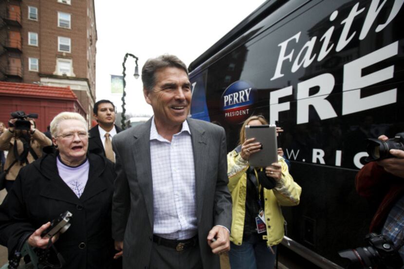 Republican presidential candidate Rick Perry walks to his bus Wednesday after he met with...