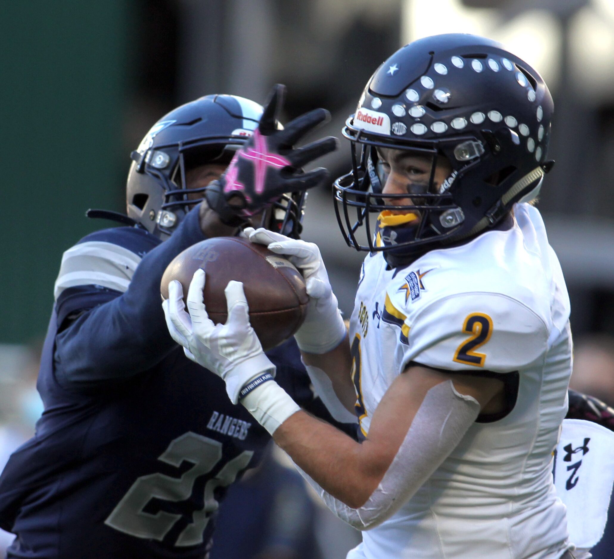 Highland Park receiver Will Pettijohn (2) pulls in a touchdown pass over the defense of...